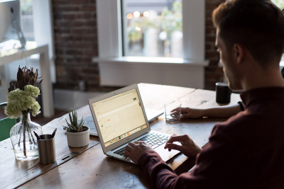 Ondernemer regelt financiële zaken gerelateerd aan corona achter laptop